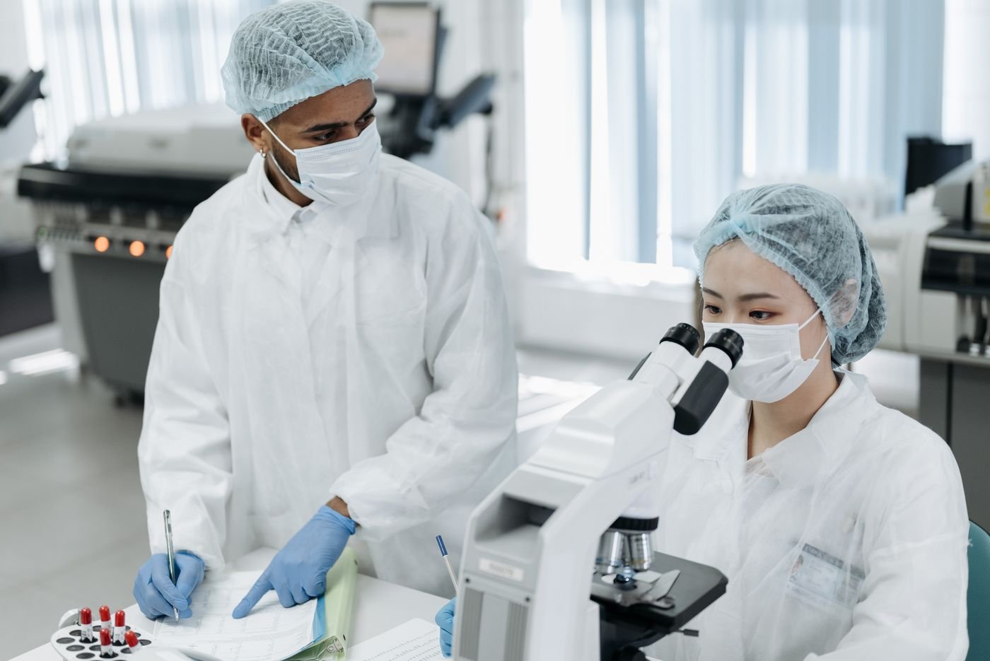 Researcher at a microscope in the Alpha Genomics laboratory